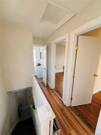 a view of a hallway with wooden floor and staircase