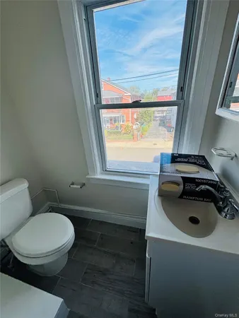 a bathroom with a sink a toilet and a window