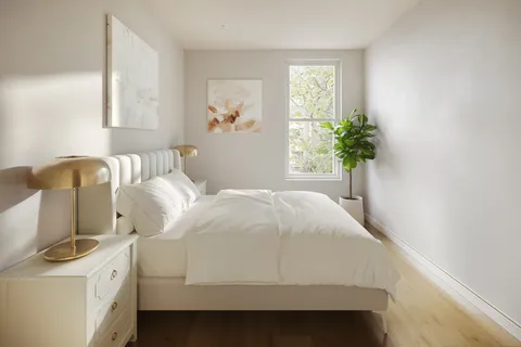 a bedroom with a bed and a potted plant