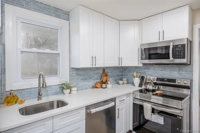 a kitchen with stainless steel appliances granite countertop a sink stove and microwave