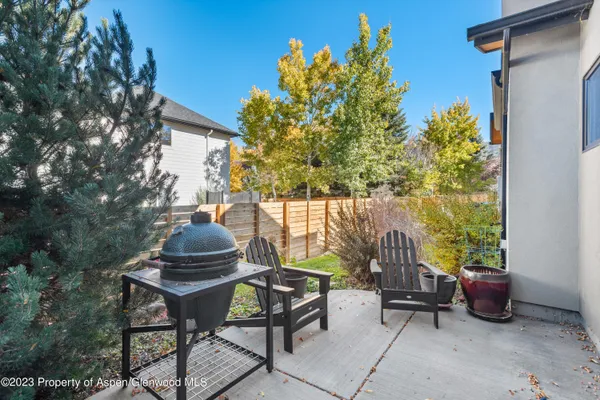 a view of a chairs and table in a back yard of the house