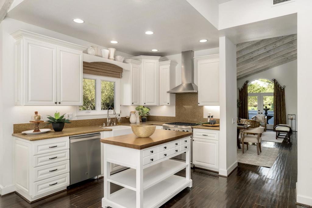 17543 Via Del Bravo Rancho Santa Fe, CA 92067 - Photo 15 of 41 a kitchen with a sink stove cabinets and wooden floor