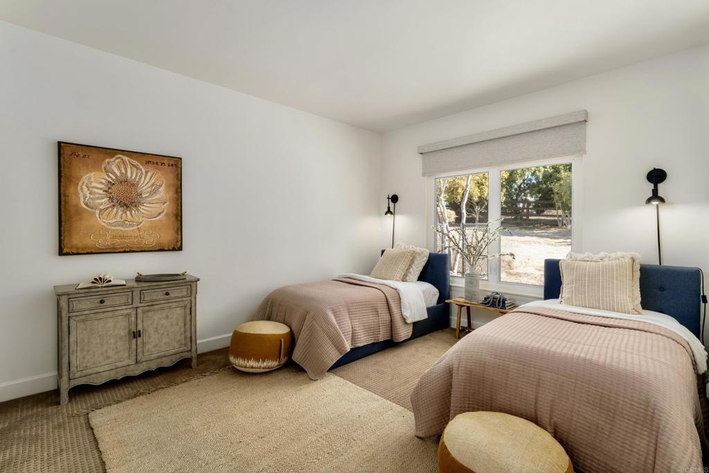 17543 Via Del Bravo Rancho Santa Fe, CA 92067 - Photo 19 of 41 a bedroom with two beds and a dresser next to a window