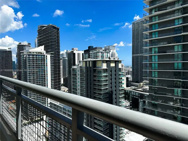 a view of an entryway with wooden floor and cabinets
