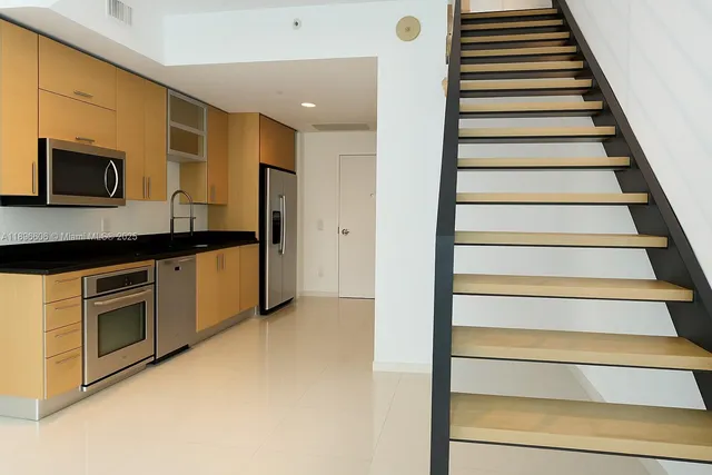 a kitchen with stainless steel appliances granite countertop a stove microwave and refrigerator