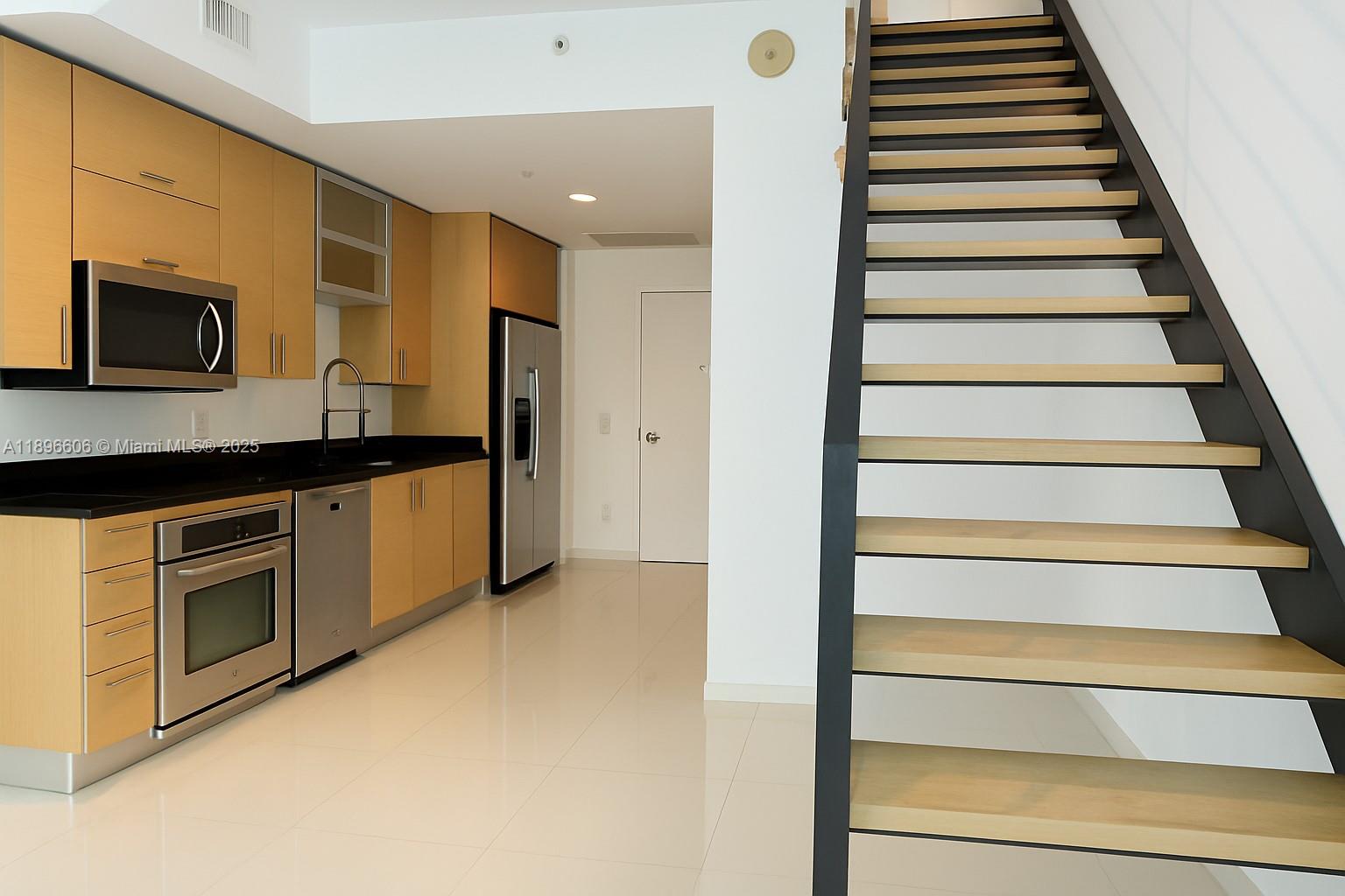 60 Southwest 13th Street, Unit 3418 Miami, FL 33130 - Photo 5 of 16 a view of an entryway with wooden floor and cabinets