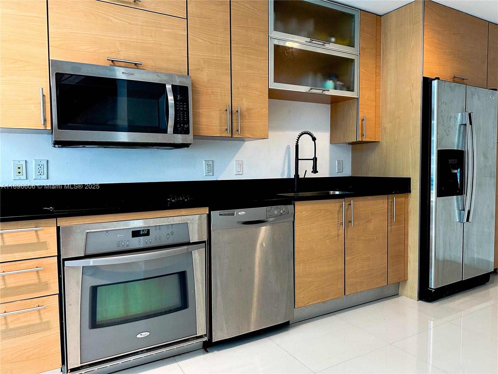60 Southwest 13th Street, Unit 3418 Miami, FL 33130 - Photo 6 of 16 a kitchen with stainless steel appliances granite countertop a stove microwave and refrigerator