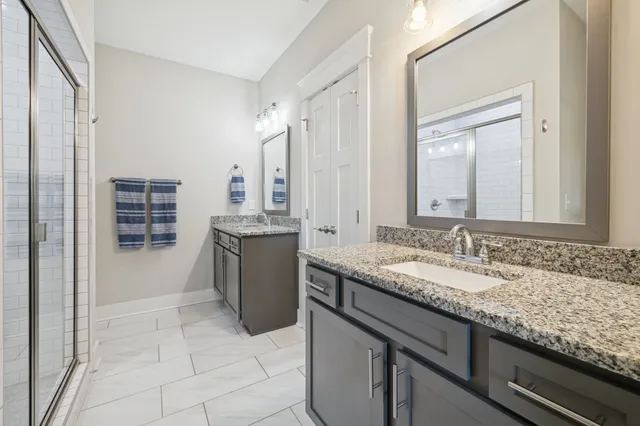 a bathroom with a granite countertop sink and a mirror