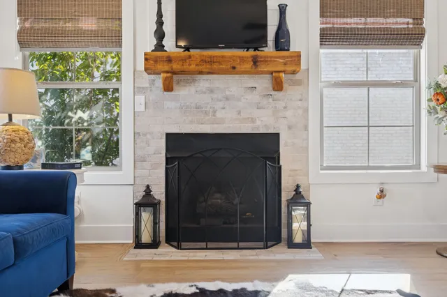 a living room with a fireplace and windows