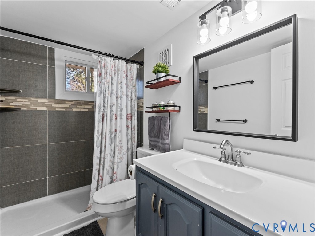1401 Bramwell Road Richmond, VA 23225 - Photo 27 of 42 a bathroom with a sink a toilet and shower