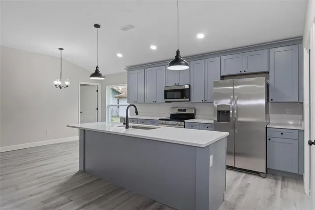 a kitchen with kitchen island a sink stainless steel appliances and cabinets