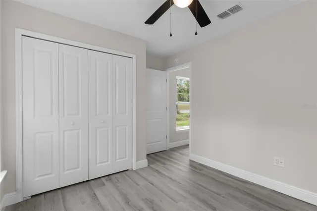 a view of a hallway with wooden floor and a cabinet