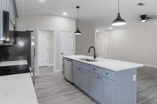 a large kitchen with kitchen island a island a sink a window and stainless steel appliances