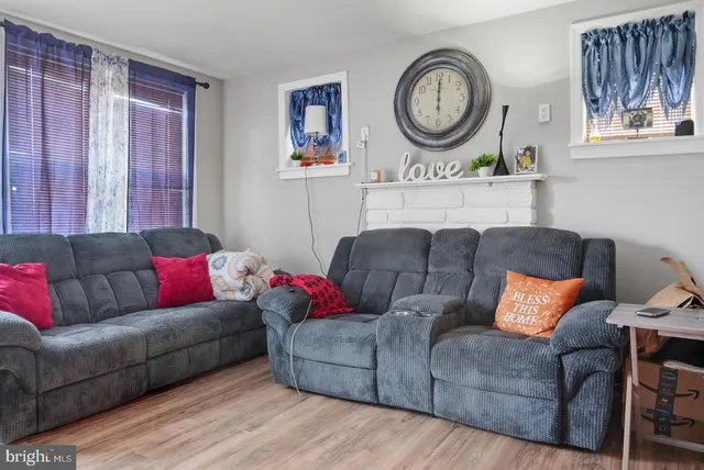 a living room with furniture a clock and a window