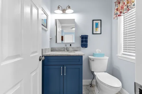 a bathroom with a toilet a sink and a large mirror