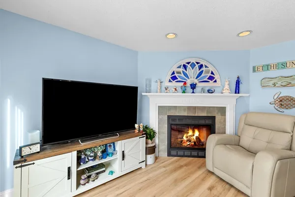 a living room with furniture a flat screen tv and a fireplace