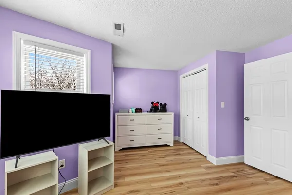 a view of a bedroom with furniture and a flat screen tv