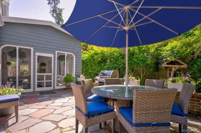 a patio with a table and chairs under an umbrella