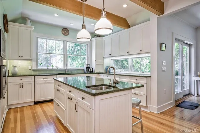 a kitchen that has a lot of cabinets and wooden floor