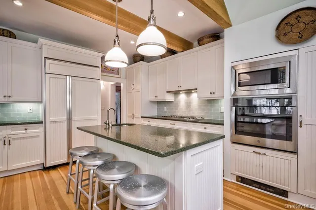 a kitchen with stainless steel appliances granite countertop a sink a stove and a wooden cabinets