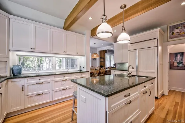 a kitchen with granite countertop a sink a stove and cabinets
