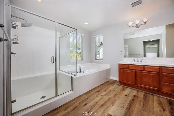 a spacious bathroom with a tub sink shower and mirror