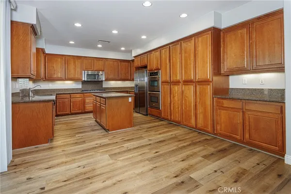 a kitchen with stainless steel appliances granite countertop a refrigerator sink and cabinets