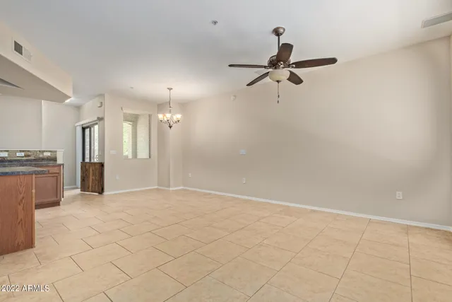 a view of a livingroom with a chandelier fan and windows