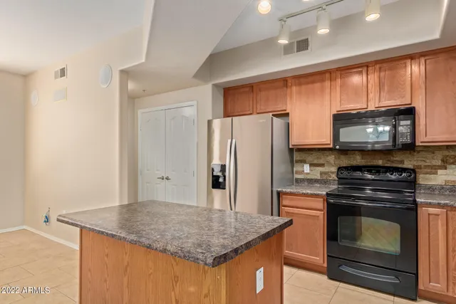 a kitchen with stainless steel appliances granite countertop wooden cabinets stove a sink and dishwasher