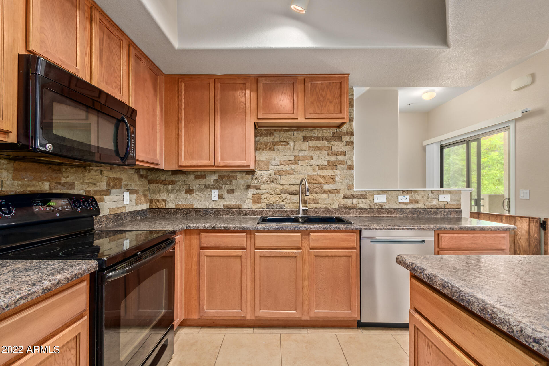 2150 West Alameda Road, Unit 1391 Phoenix, AZ 85085 - Photo 23 of 63 a kitchen with stainless steel appliances granite countertop wooden cabinets stove a sink and dishwasher
