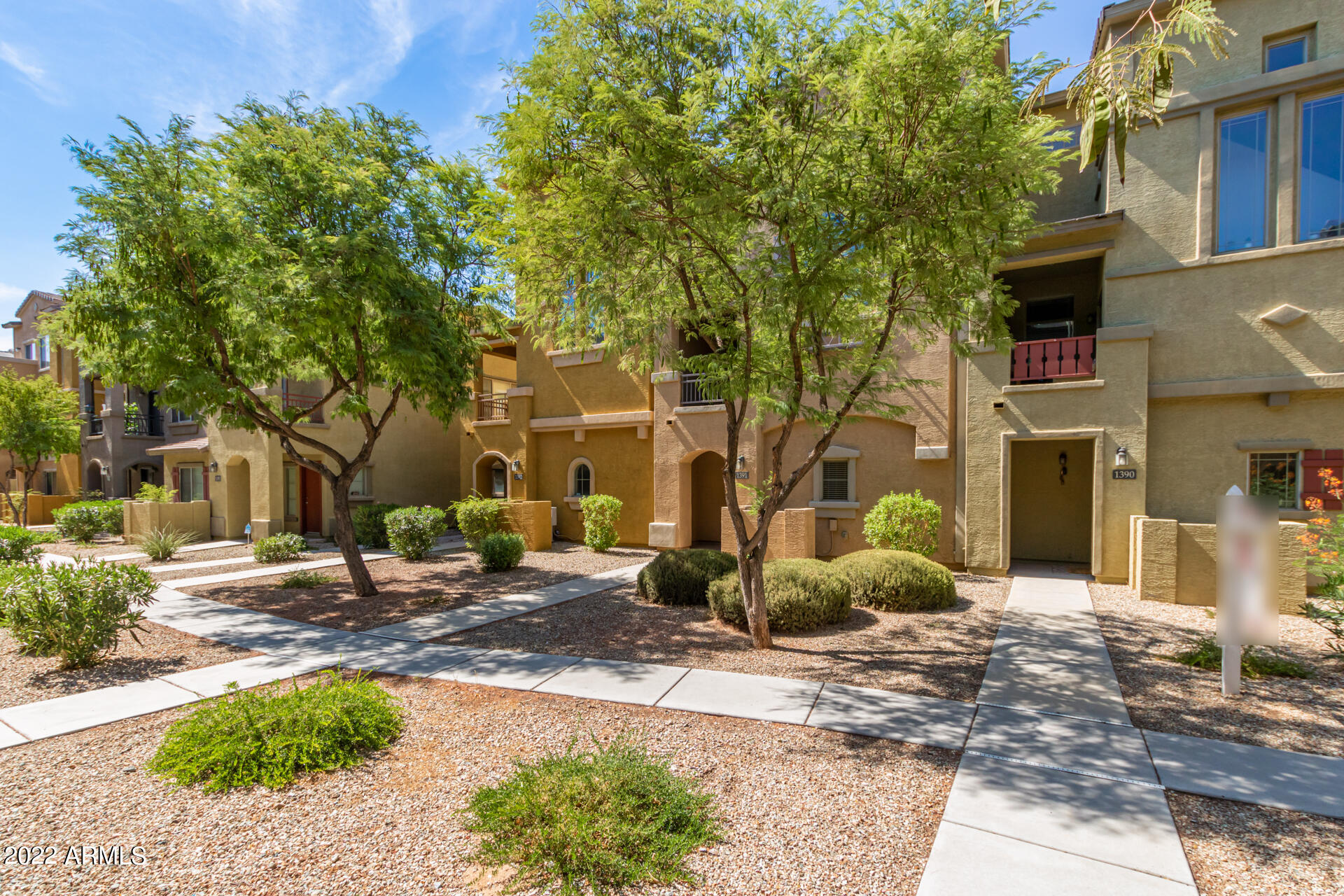 2150 West Alameda Road, Unit 1391 Phoenix, AZ 85085 - Photo 5 of 63 a view of a brick house with many windows plants and large tree