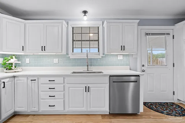 a kitchen with granite countertop white cabinets and stainless steel appliances