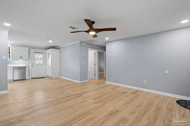 a view of an empty room with a ceiling fan and window