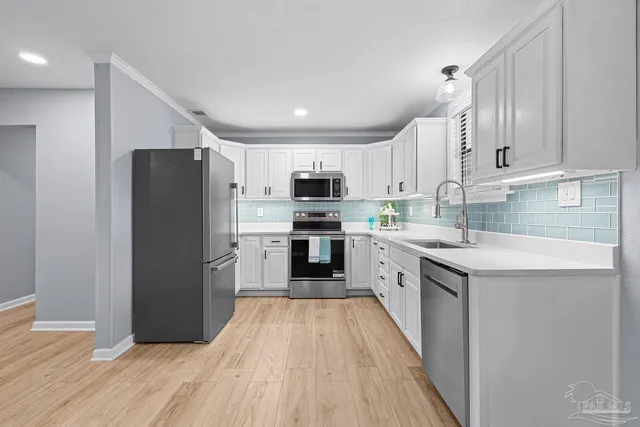 a kitchen with granite countertop a refrigerator oven a sink dishwasher and a stove with wooden floor