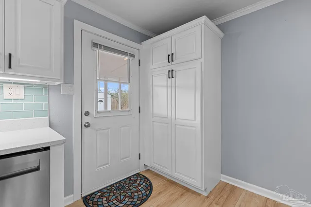 a view of kitchen with white cabinets and front door