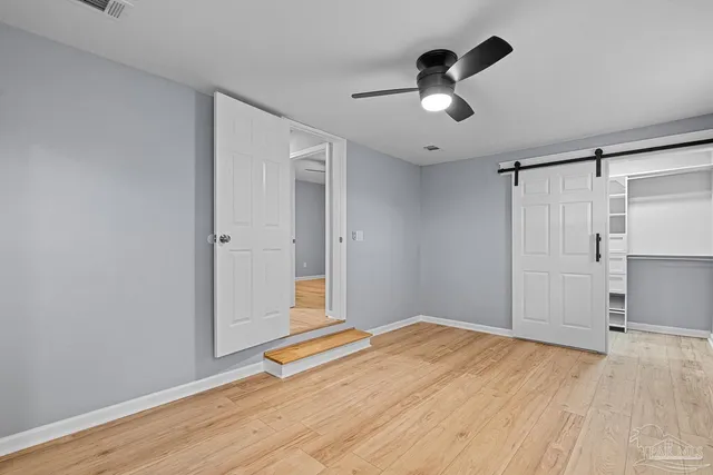 a view of empty room with wooden floor