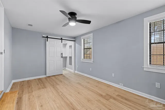 a view of empty room with wooden floor and window