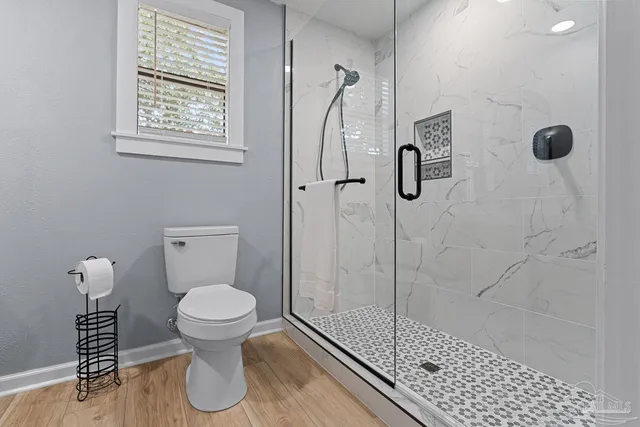 a bathroom with a toilet and a shower