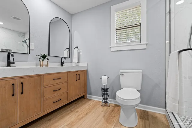 a spacious bathroom with double vanity a toilet a and a window