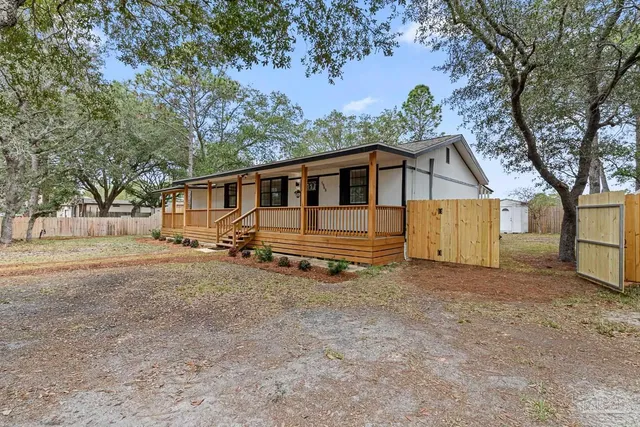 a front view of a house with a garden and trees
