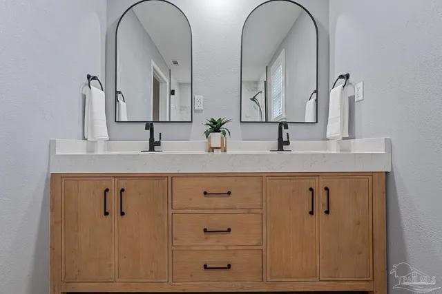 a bathroom with a double vanity sink and mirror