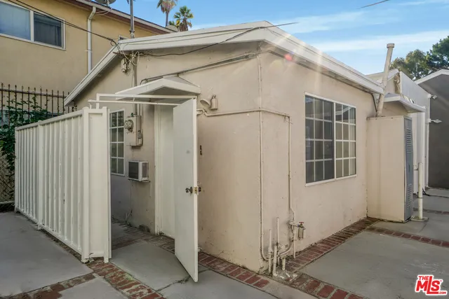 a view of an empty room with window and chandelier fan