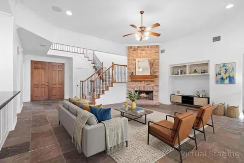 a view of an empty room with stairs and a chandelier fan