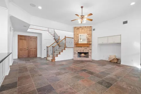 a view of an empty room with window and fire place