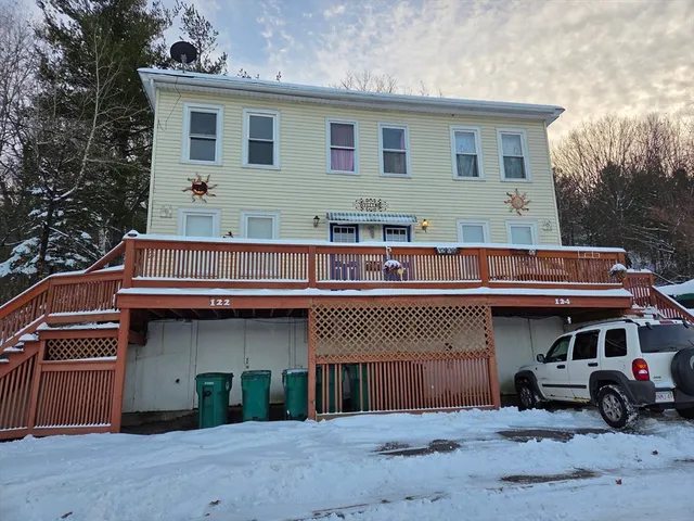 a view of a house with a balcony and parking space
