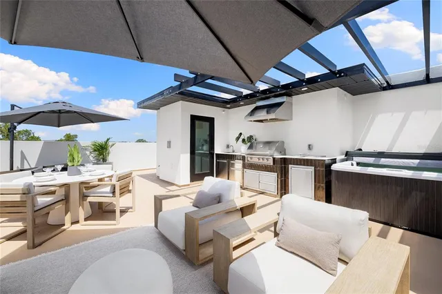 a kitchen with stainless steel appliances kitchen island granite countertop a sink a stove a dining table and chairs