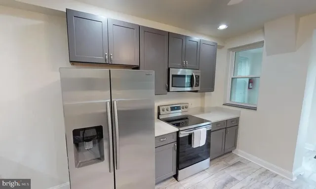 a kitchen with stainless steel appliances granite countertop a refrigerator stove and microwave