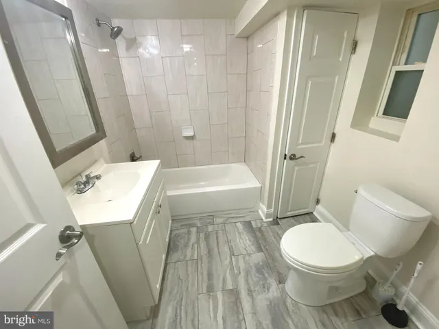 a white toilet sitting next to a bath tub