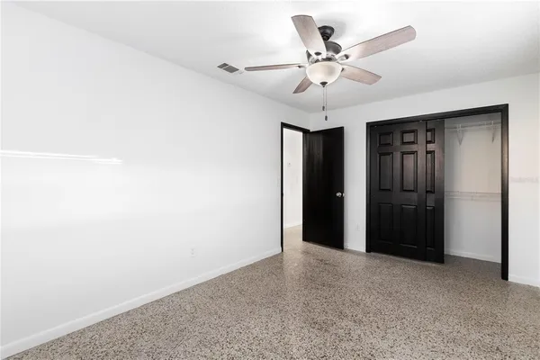 a view of an empty room with a ceiling fan