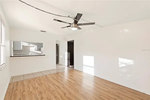 a view of a kitchen with wooden floor and a ceiling fan